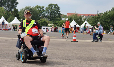 Rollstuhlfahrer mit Staffelstab